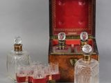 three glass bottles and a wooden box with a red lid