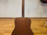a close up of a guitar on a stand on a hard wood floor