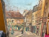 une photo d'un tableau posé sur une table à côté d'une valise