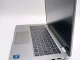 a silver laptop computer sitting on a white surface