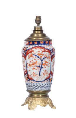 une image représentant un vase à pied doré, orné d'un motif rouge et bleu