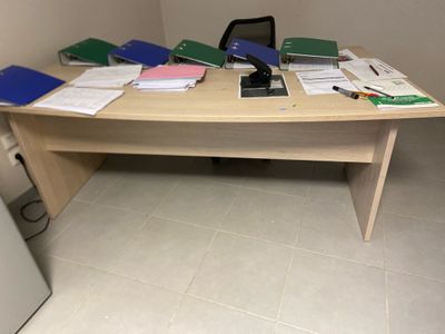 a desk with a laptop and a lot of papers on it
