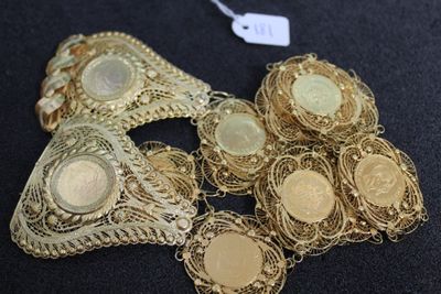 several pieces of gold jewelry on a black surface with a price tag