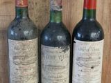three bottles of wine sitting on a shelf next to each other