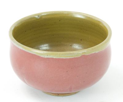 a pink and green bowl sitting on a white surface