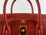 a close up of a brown handbag on a white surface