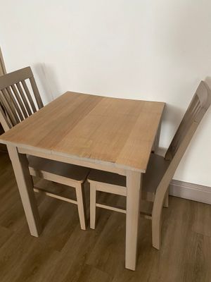 a small table and two chairs in the corner of the room