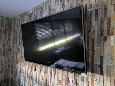 une télévision à écran plat fixée au mur dans le salon