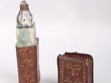 a small book and a small bottle sitting next to each other