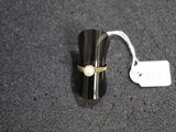 a close up of a ring on a black surface with a price tag
