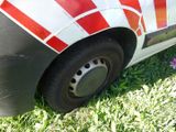 a red and white striped car parked in the grass