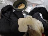 a pile of clothes and a hat sitting on a bed