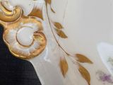 a white and gold plate with a floral design on it