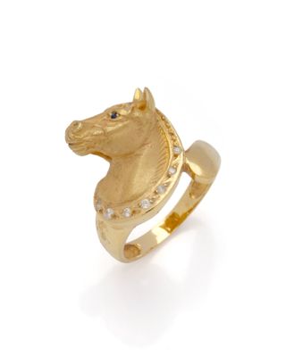 une image représentant une bague en forme de tête de cheval en or sur fond blanc
