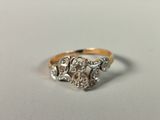 a close up of a gold and diamond ring on a white surface