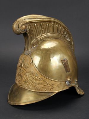 un casque ancien en laiton sur fond noir avec un fond gris