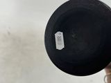 someone is holding a black vase with a tag on it