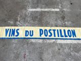 un panneau de signalisation portant l'inscription « vins du position » posé sur le trottoir