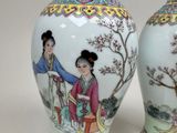 pair of asian vases with asian women and trees on them
