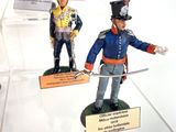 several figurines of soldiers are displayed on display in a glass case
