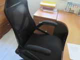 a black office chair sitting in front of a wooden desk