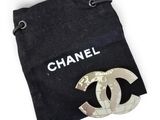 chanel brooch in a black bag with a white logo on it