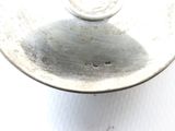 a close up of a silver plate on a white surface