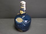 a blue bottle that has a gold label on it