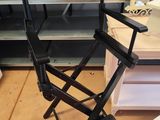 une chaise de réalisateur noire au milieu d'une pièce