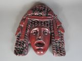 un gros plan sur une sculpture rouge représentant le visage d'une femme