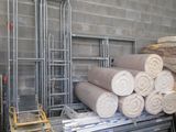 many rolls of fabric sitting on a pallet in a warehouse