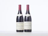 two bottles of wine sitting on top of a white table