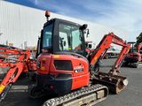 a picture of a red and black tractor parked in a parking lot