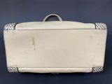 an old white suitcase sitting on top of a blue surface