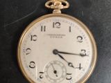 a gold pocket watch sitting on top of a black table