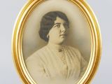 an old photo of a woman in a white dress in a gold frame