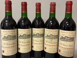 four bottles of wine are lined up on a table