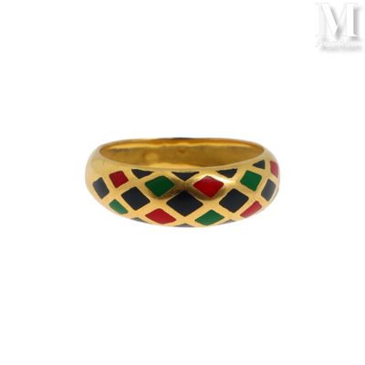 un gros plan d'une bague en or ornée de carrés noirs, rouges et verts