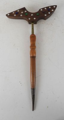 a close up of a knife with a wooden handle on a white surface