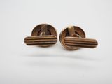 a pair of gold cufflinks with purple stones on them