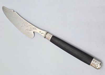 un couteau au manche noir posé sur une table