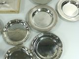 a lot of silver plates and silverware on a table