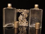 three glass bottles sitting on a table with gold decorations on them