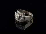 a close up of a silver ring with diamonds on a black surface