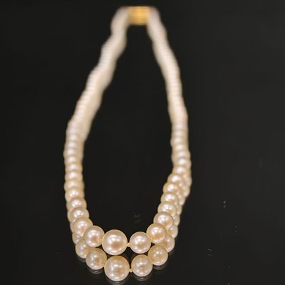 gros plan d'un collier de perles sur une surface noire