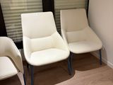 three white chairs in a waiting room next to a window