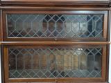 a wooden cabinet with a glass door on top of it