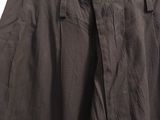 black pants hanging on a hanger on a white wall