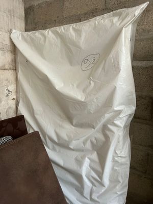 a white sheet with a smiley face on it next to a brown bag