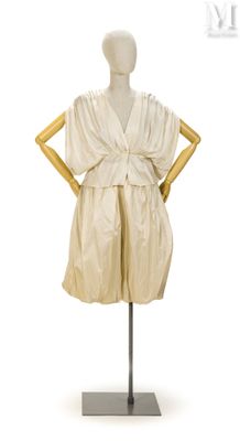 une photo d'un mannequin portant une robe blanche, posé sur un socle